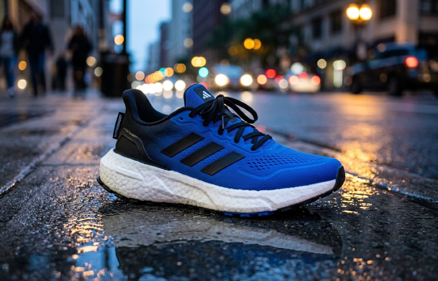 adidas Hyperboost Euphoria in blauw-zwart met witte Hyperboost midsole op nat stadsasfalt met avondlicht