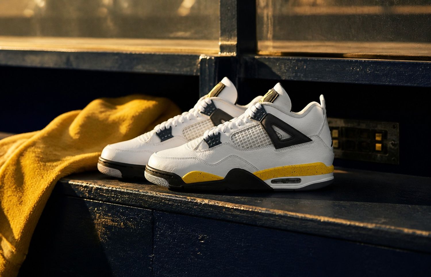 Air Jordan 4 Tour Yellow IO2463-102 op een vintage basketbalbank
