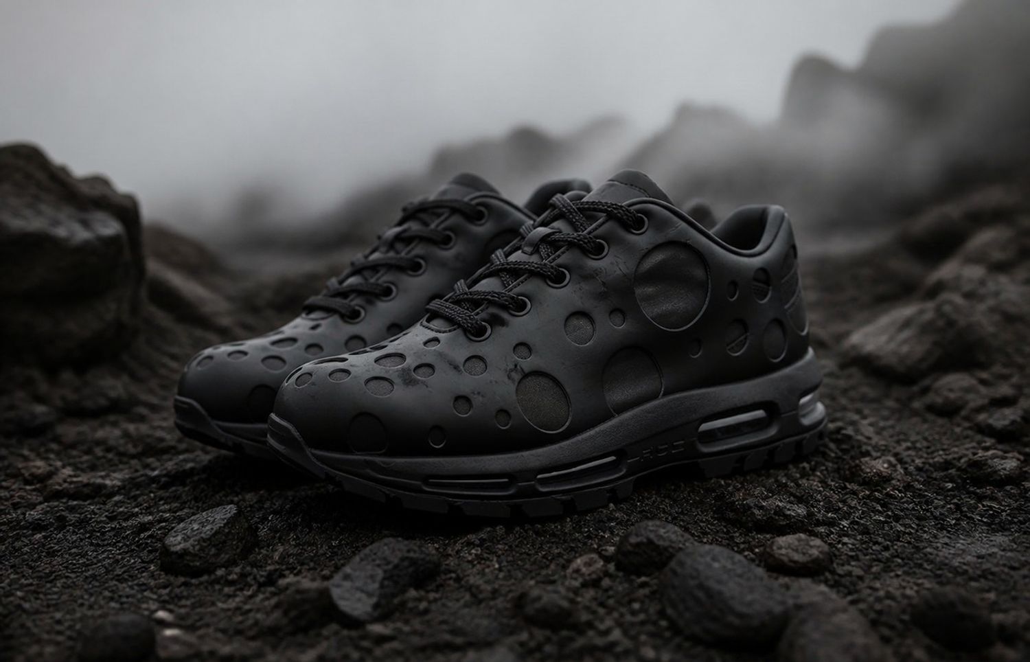 Nike Air Max Goadome Low Black op een donkere rotsachtige ondergrond