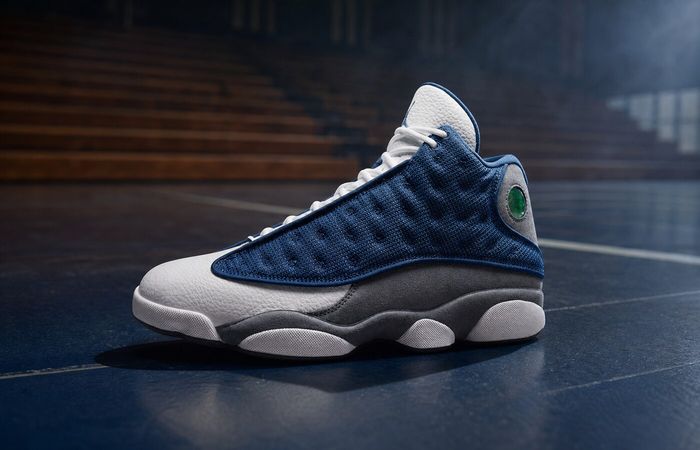 Air Jordan 13 Navy and Flint Grey op een donker basketbalcourt