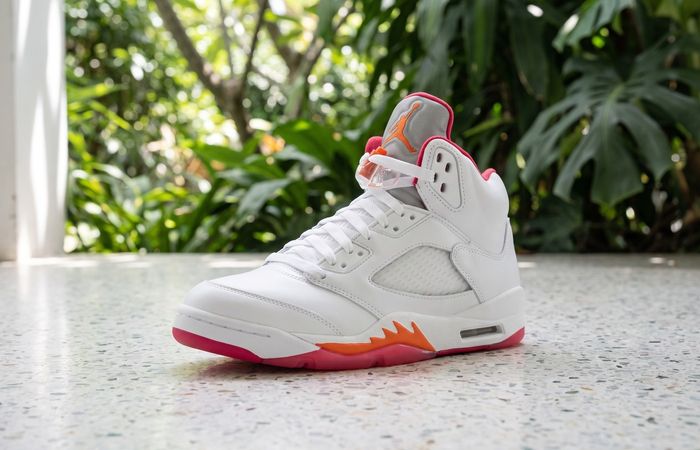 Air Jordan 5 Sunset met wit leer, zilveren tong en oranje-roze zool op terrazzo bij een groene veranda