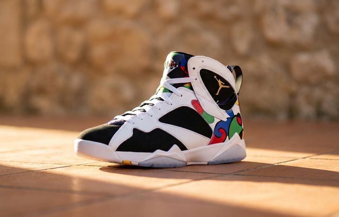 Air Jordan 7 Retro Miro met kleurrijke abstracte graphics op terracotta tegelvloer in mediterraan licht
