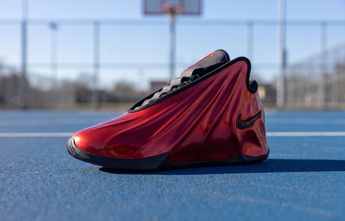 Nike G.T. Future Varsity Red met een glanzend rode gevormde upper op een blauwe basketbalcourt